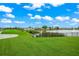 View of the golf course that surrounds the lake, with mature landscaping and a water fountain, offering serene community views at 6524 Fairway Gardens Dr # 6524, Bradenton, FL 34203