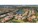 Aerial view of a community featuring homes with mature trees and lake views at 8079 36Th Street E Cir, Sarasota, FL 34243