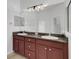 Bathroom features a double vanity with granite counters, a large mirror, and tile floors at 8079 36Th Street E Cir, Sarasota, FL 34243