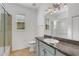 Well-lit bathroom features a granite countertop and shower with glass door at 8079 36Th Street E Cir, Sarasota, FL 34243