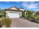 Classic home featuring a paved driveway, lush landscaping, and a well-manicured lawn at 8079 36Th Street E Cir, Sarasota, FL 34243