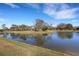 Scenic view of a pond reflecting the sky, surrounded by trees and the roofs of nearby homes at 8079 36Th Street E Cir, Sarasota, FL 34243