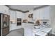 Kitchen features white cabinets, granite island, and stainless steel appliances at 8548 Snowfall St, Sarasota, FL 34241