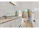 Bathroom boasts double sinks, granite countertops, and a shower/tub combo with colorful curtain at 907 Garland Ave, Nokomis, FL 34275