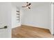 A bright bedroom has wood floors, a ceiling fan, and built-in shelves at 907 Garland Ave, Nokomis, FL 34275