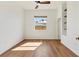Bright bedroom featuring wood floors, a large window, and built-in shelving at 907 Garland Ave, Nokomis, FL 34275