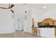 Bright kitchen and living area with tile floors, breakfast bar and modern ceiling fan and fixtures at 907 Garland Ave, Nokomis, FL 34275
