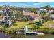 An aerial view of a home with a screened-in pool, green lawn, and dock on the water at 907 Garland Ave, Nokomis, FL 34275