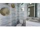 Powder room with patterned wallpaper and granite countertop at 9113 Night Skye Ave, Sarasota, FL 34241