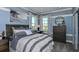 Serene bedroom with gray and white bedding and a dresser at 9113 Night Skye Ave, Sarasota, FL 34241