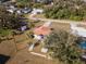 An aerial view of single-Gathering home with a well-maintained lawn, mature trees, and a sparkling blue swimming pool at 1058 Bounds St, Port Charlotte, FL 33952