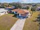 Aerial view of a well-maintained single-story home with a spacious yard and long driveway at 1058 Bounds St, Port Charlotte, FL 33952