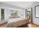 This bright main bedroom features wood floors, a large window and glass door leading outside at 1058 Bounds St, Port Charlotte, FL 33952
