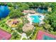 Stunning aerial view of community amenities including a pool, playground, tennis courts, and a scenic lake at 12514 Goldenrod Ave, Bradenton, FL 34212