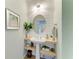 Stylish half-bathroom with shiplap accent wall, floating shelves, pedestal sink and an oval mirror at 12514 Goldenrod Ave, Bradenton, FL 34212