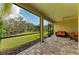 Relaxing covered patio featuring brick flooring, an outdoor seating area, and views of the expansive green backyard at 12514 Goldenrod Ave, Bradenton, FL 34212