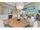 Open concept dining room with a decorative chandelier, a blue tray ceiling, and views to the kitchen and living room at 12514 Goldenrod Ave, Bradenton, FL 34212