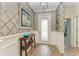 Inviting foyer featuring stylish wallpaper, elegant decor, and wood-look flooring at 12514 Goldenrod Ave, Bradenton, FL 34212