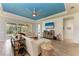 Living room with a light colored sofa, a large screened in window, and a blue tray ceiling with a fan at 12514 Goldenrod Ave, Bradenton, FL 34212