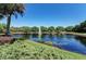 Scenic view of a pond featuring a fountain, lush trees, and various water plants at 12514 Goldenrod Ave, Bradenton, FL 34212