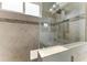 Walk-in shower with gray tile surround, a glass door, and a rain shower head at 12514 Goldenrod Ave, Bradenton, FL 34212