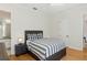Bedroom with modern decor, including a gray bed frame, striped bedding, and light hardwood floors at 13315 Palmers Creek Ter, Lakewood Ranch, FL 34202
