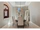 Elegant dining room featuring stylish wallpaper, a chandelier, and a view into the foyer at 13315 Palmers Creek Ter, Lakewood Ranch, FL 34202