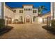Stunning two-story home with well-maintained landscaping, a brick driveway, and a secure wrought iron gate entrance at 13315 Palmers Creek Ter, Lakewood Ranch, FL 34202