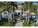 Stately home exterior with a tile roof, palm trees, and manicured landscaping at 13315 Palmers Creek Ter, Lakewood Ranch, FL 34202