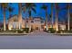 Elegant two-story home featuring lush landscaping, mature palm trees, and a beautiful paver driveway and walkway at 13315 Palmers Creek Ter, Lakewood Ranch, FL 34202