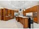 Bright kitchen featuring an island, custom cabinets, marble counters, and stainless steel refrigerator at 13315 Palmers Creek Ter, Lakewood Ranch, FL 34202