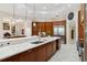 Spacious kitchen boasts marble countertops, stainless steel refrigerator, wood cabinetry and open floor plan at 13315 Palmers Creek Ter, Lakewood Ranch, FL 34202