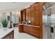 Kitchen coffee bar featuring custom cabinets, marble countertops, and stainless steel refrigerator at 13315 Palmers Creek Ter, Lakewood Ranch, FL 34202