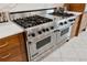 Close-up of a gourmet range with stainless steel appliances and marble countertops at 13315 Palmers Creek Ter, Lakewood Ranch, FL 34202