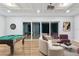 Open concept living room with a pool table, comfortable seating, and a sliding glass door leading to the outside at 13315 Palmers Creek Ter, Lakewood Ranch, FL 34202