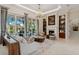 Inviting living room with custom built-ins, a fireplace, and large windows overlooking the outdoor area at 13315 Palmers Creek Ter, Lakewood Ranch, FL 34202
