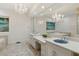 Luxurious bathroom with dual vanities, and a large tub under a chandelier at 13315 Palmers Creek Ter, Lakewood Ranch, FL 34202