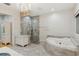 Marble bathroom featuring a glass shower, soaking tub, and elegant chandelier at 13315 Palmers Creek Ter, Lakewood Ranch, FL 34202
