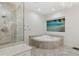 Elegant bathroom with a shower, soaking tub, and beach view from the window at 13315 Palmers Creek Ter, Lakewood Ranch, FL 34202
