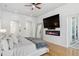 Main bedroom featuring a fireplace, TV, and access to a balcony at 13315 Palmers Creek Ter, Lakewood Ranch, FL 34202