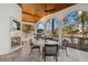 Outdoor living area featuring a fireplace, bar seating, and wood plank ceiling at 13315 Palmers Creek Ter, Lakewood Ranch, FL 34202