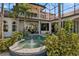 Stunning pool area enclosed with glass walls, tropical plants, arches, and comfortable outdoor seating at 13315 Palmers Creek Ter, Lakewood Ranch, FL 34202