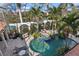 Stunning pool area enclosed with glass walls, tropical plants, arches, and comfortable outdoor seating at 13315 Palmers Creek Ter, Lakewood Ranch, FL 34202