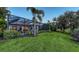 Well-maintained backyard with lush green lawn, enclosed pool, and surrounding greenery at 14510 Leopard Creek Pl, Lakewood Ranch, FL 34202