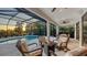 Outdoor space featuring a screened-in pool, lounge chairs, and a cozy seating area with a fire pit at 14510 Leopard Creek Pl, Lakewood Ranch, FL 34202