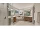 Bright bathroom with double sinks, a soaking tub, and a glass-enclosed shower at 14510 Leopard Creek Pl, Lakewood Ranch, FL 34202