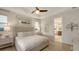 Well-lit bedroom with a ceiling fan, ensuite bathroom, and neutral decor at 14510 Leopard Creek Pl, Lakewood Ranch, FL 34202