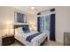 Cozy bedroom with a ceiling fan, blue accents, a floral comforter, and natural light at 14510 Leopard Creek Pl, Lakewood Ranch, FL 34202