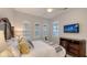 Bedroom with wall-mounted TV, shuttered windows, and wooden furniture at 14510 Leopard Creek Pl, Lakewood Ranch, FL 34202