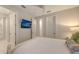Bedroom with television and ensuite bath featuring neutral walls and white trim at 14510 Leopard Creek Pl, Lakewood Ranch, FL 34202